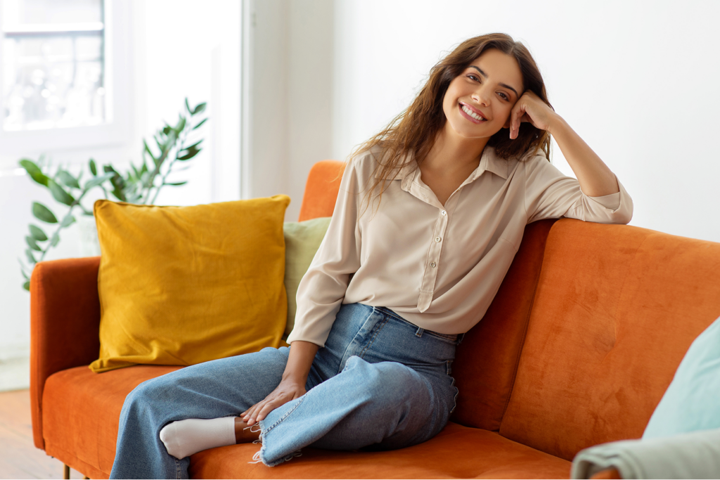 Frau auf Sofa l&auml;chelnd